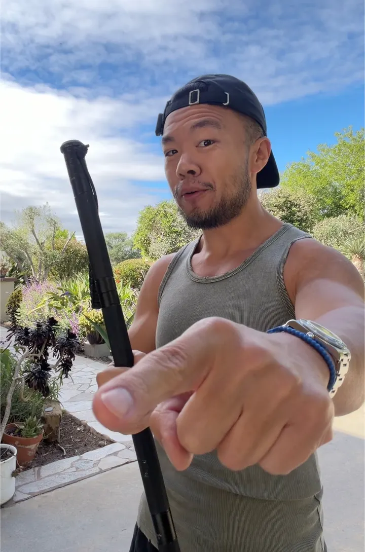 Gavin addressing the camera with a hiking stick outdoors